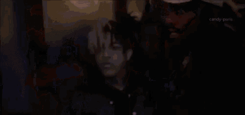 a man with dreadlocks is standing in a crowd of people .