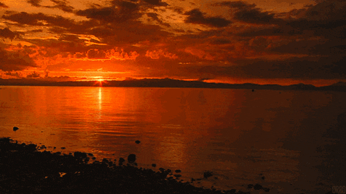 a picture of a sunset over a body of water taken by a person named chris