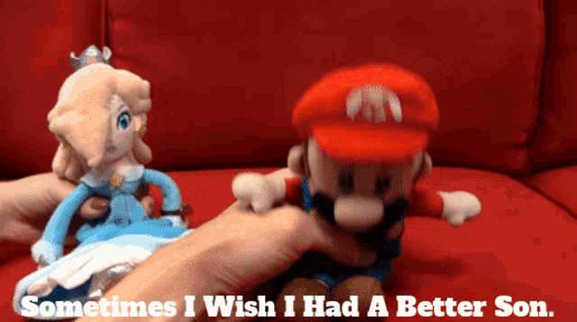 a person is holding a mario and princess peach stuffed toy