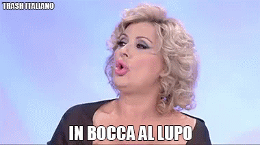 a woman is making a funny face with the words in bocca al lupo written below her
