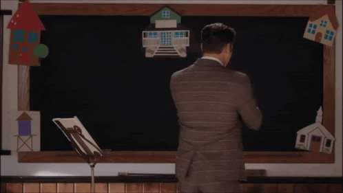 a man in a suit and tie is standing in front of a blackboard with the words casting by candice elzinga and martina smyth