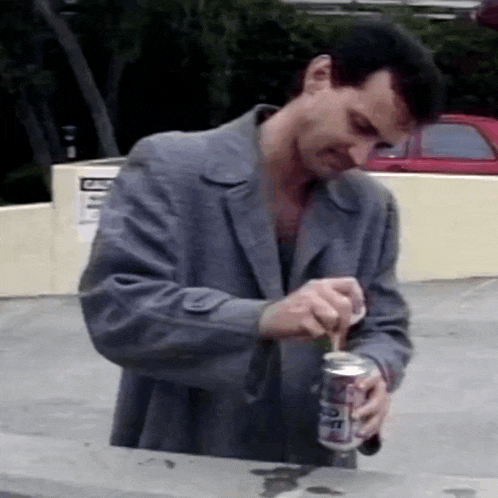 a man in a suit is opening a can of diet coke