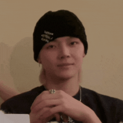 a young man wearing a black beanie and a ring