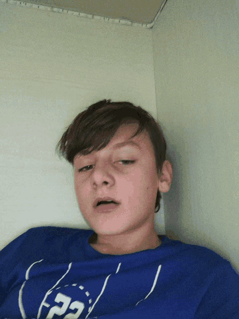 a young boy wearing a blue shirt with the letters p2 on it