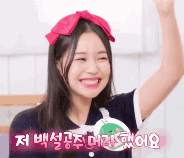 a girl with a red bow on her head is smiling with a sticker that says vs on it