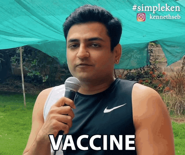 a man is holding a microphone with the word vaccine on it