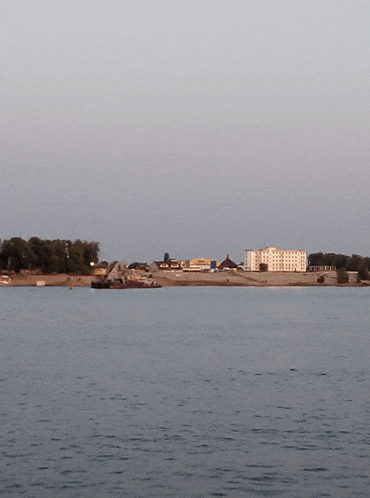 a large body of water with a few buildings in the background