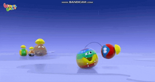 a group of colorful balls with faces on them are on a blue surface .