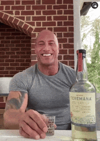 a man sitting at a table with a bottle of teremana