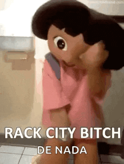 a doll with a backpack is sitting on the floor in a bathroom with the words `` rack city bitch de nada '' .