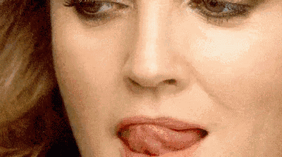 a close up of a woman 's face with her tongue hanging out .