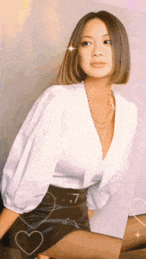 a woman wearing a white top and a black skirt with hearts around her
