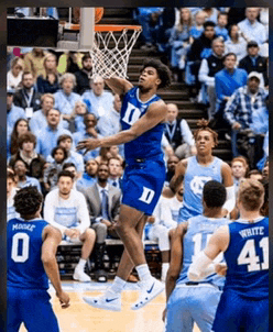 a basketball player wearing a blue jersey with the letter d on it jumps in the air