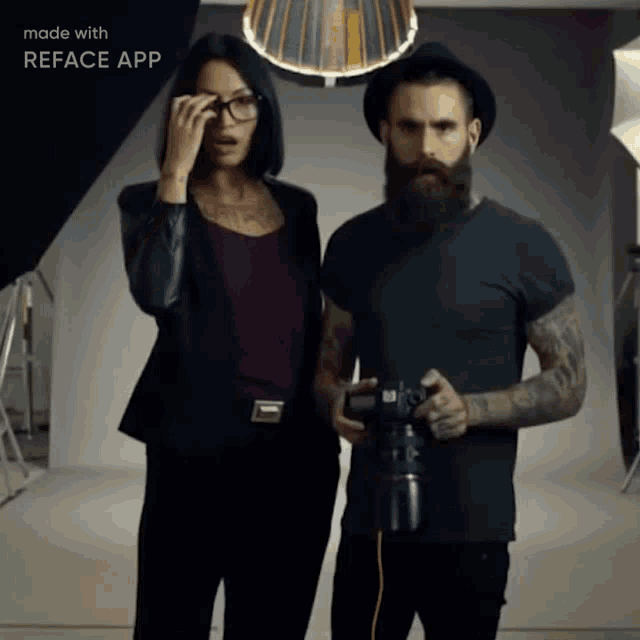 a man with a beard holds a camera next to a woman