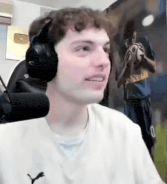 a man wearing headphones is sitting in front of a microphone .