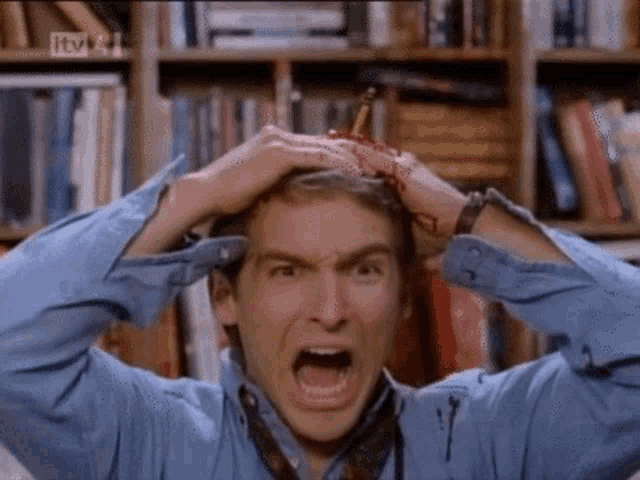 a man with a pencil in his head is screaming in front of a tv screen that says itv on it