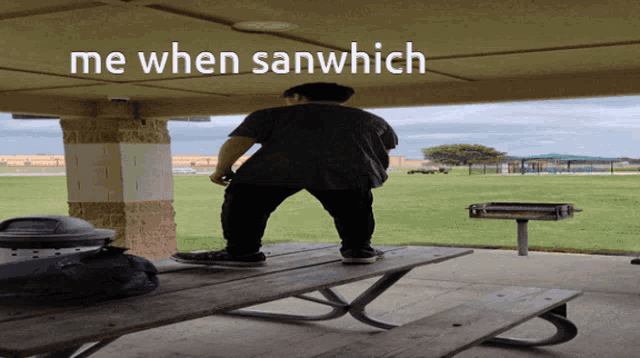 a man standing on top of a picnic table with the words me when sanwhich above him