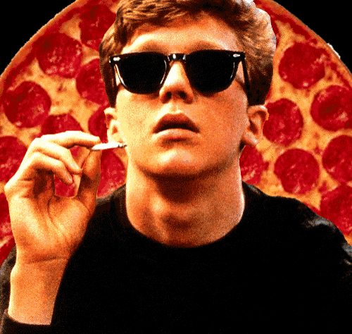 a man wearing sunglasses is smoking a cigarette in front of a large pepperoni pizza
