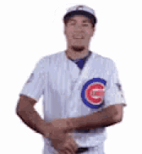a baseball player in a cubs uniform is shaking hands with another player .