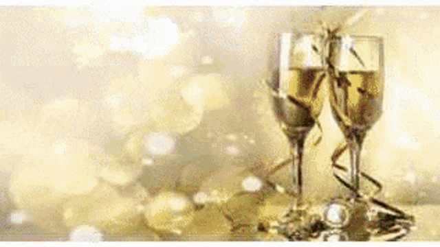 two glasses of champagne are sitting on a table with gold decorations .