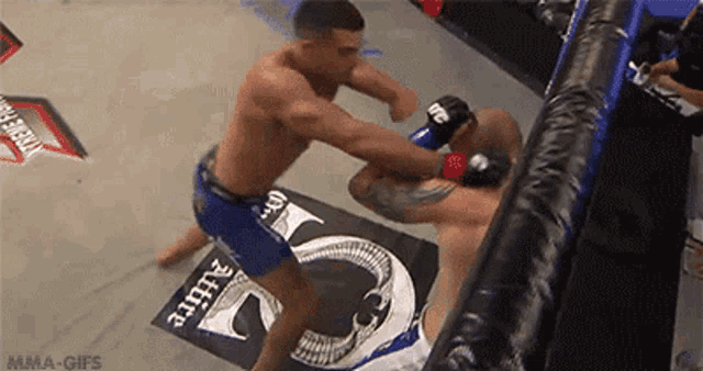 two men are fighting in a boxing ring with a sign that says mma-gifs