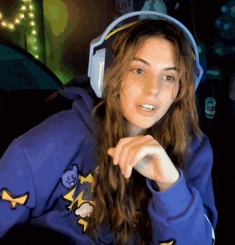 a woman wearing headphones and a blue sweatshirt with a lightning bolt on the front