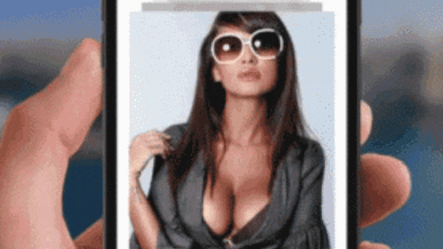 a person is holding a cell phone with a picture of a woman 's breasts on it