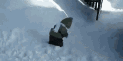a small gnome is walking through the snow .