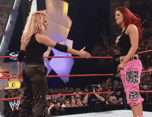 two women in a wrestling ring with one wearing pink pants that say ' nirvana ' on them