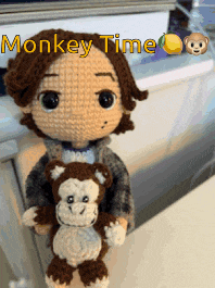 a crocheted doll holding a stuffed monkey with the words monkey time written above it