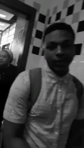 a black and white photo of a man standing in a hallway