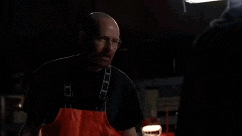 a man in an apron is screaming in a dark room with the word done written on the screen .