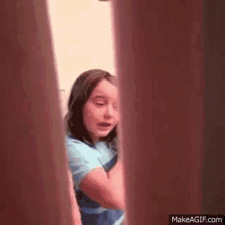 a little girl is crying while standing in a doorway .