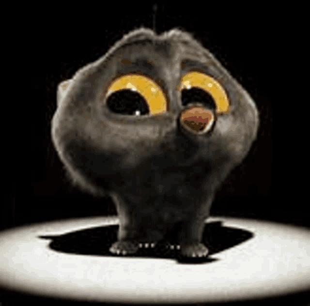 a cartoon cat with big yellow eyes is sitting on top of a white table .