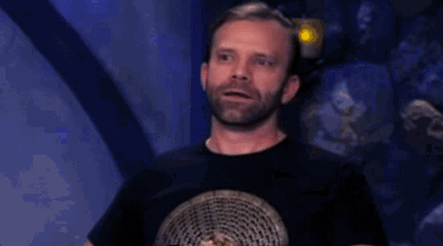 a man with a beard and a black shirt is making a funny face .
