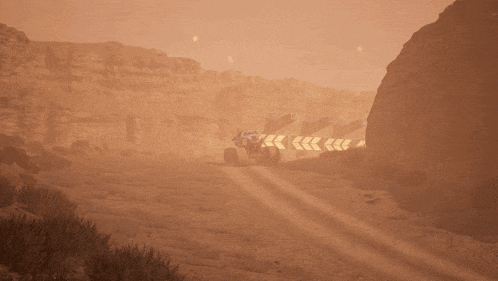 a vehicle is driving down a dirt road in the desert