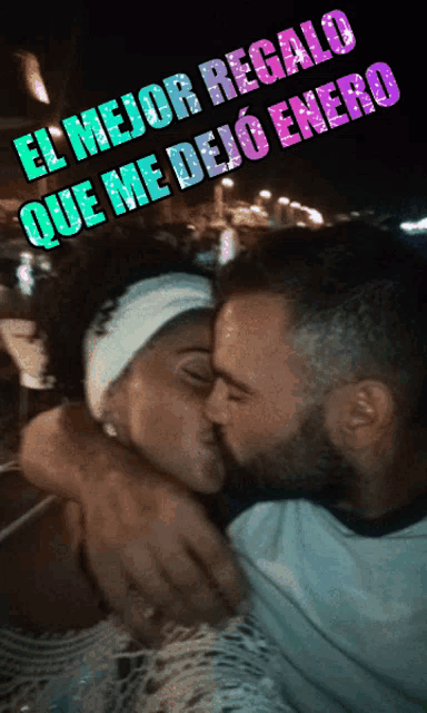 a man kissing a woman with the words el mejor regalo que me dejo enero