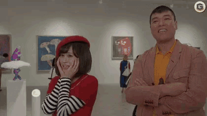 a man and a woman are standing in a museum .