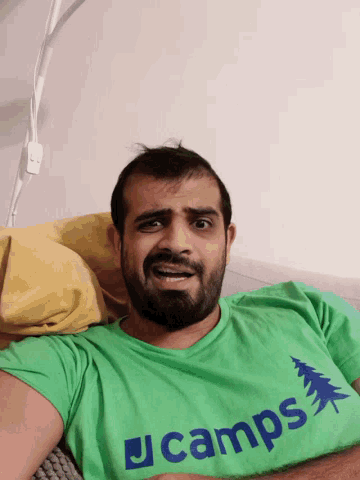 a man wearing a green t-shirt that says j camps