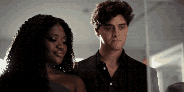 a man and a woman are standing next to each other in a dark room