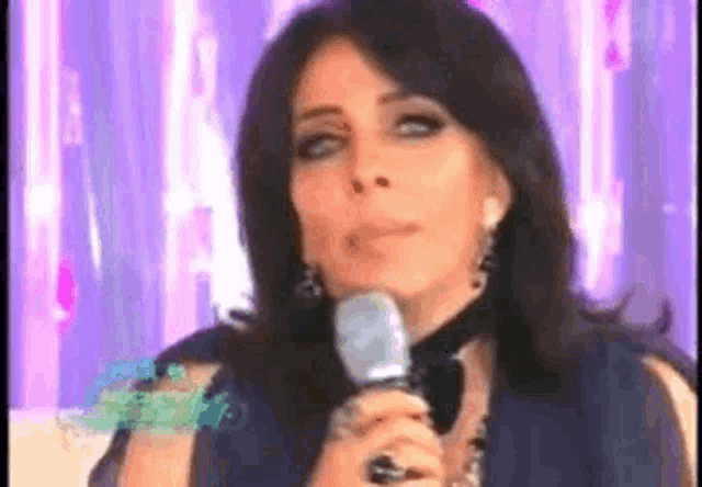 a woman is holding a microphone in front of her face