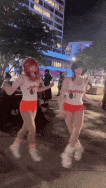 two hooters girls are jumping in the air at night
