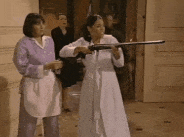 two women are standing next to each other holding guns