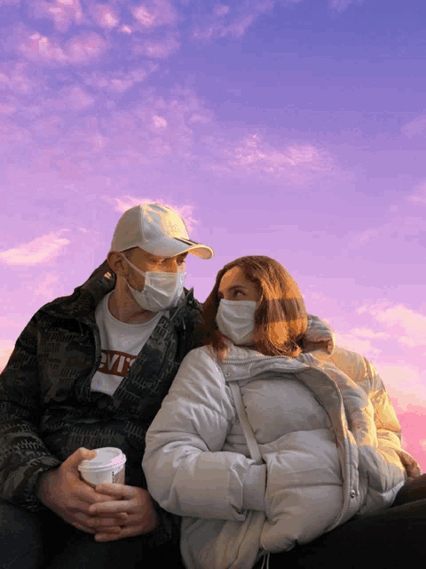 a man wearing a levi 's jacket sits next to a woman wearing a face mask