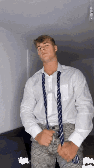 a man in a white shirt and tie is standing in a room