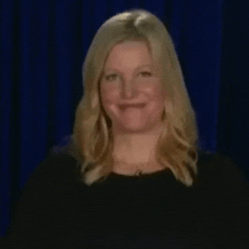 a woman with blonde hair and a black shirt is making a funny face