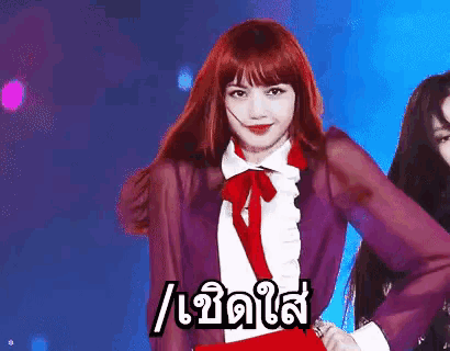 a woman with red hair is wearing a purple shirt with a red bow tie and a red skirt .