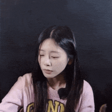 a girl wearing a pink sweater that says g n on it