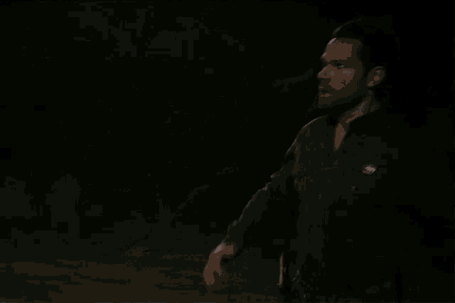 a man in a dark room with a badge on his chest that says ' u.s. army ' on it