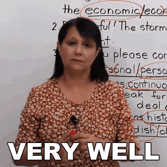 a woman stands in front of a white board with the words " very well " written on it